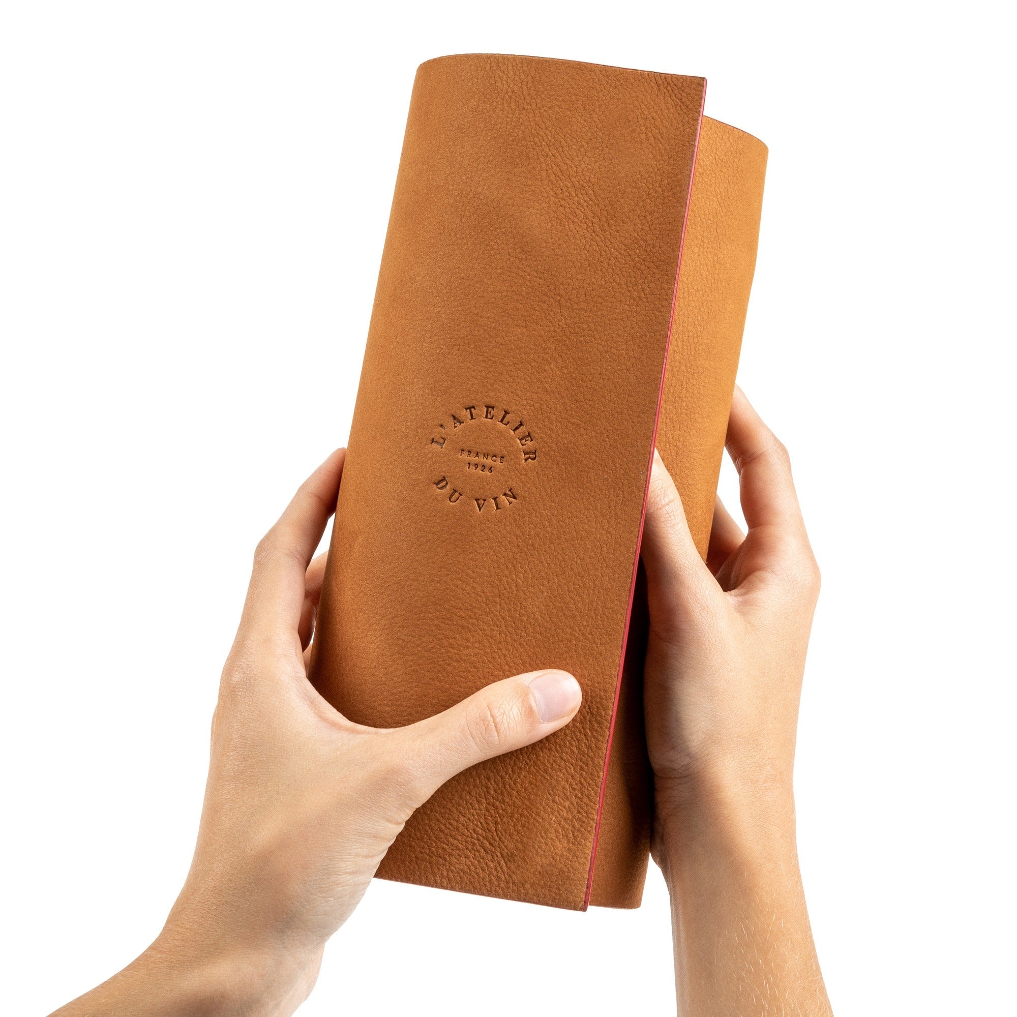 Manos sosteniendo el estuche nómada L'Atelier du Vin Oeno Collection Nomad cerrado en cuero natural
