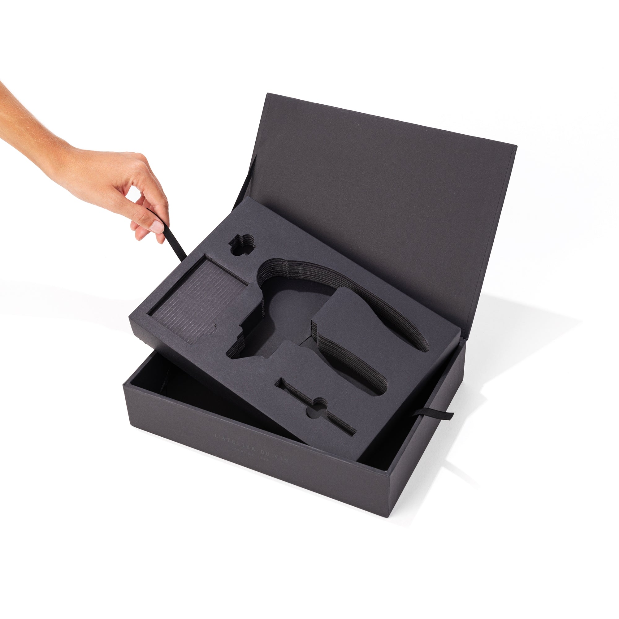 Caja Oeno Box Sommelier de L'Atelier du Vin con calaje extraíble siendo retirado con la mano