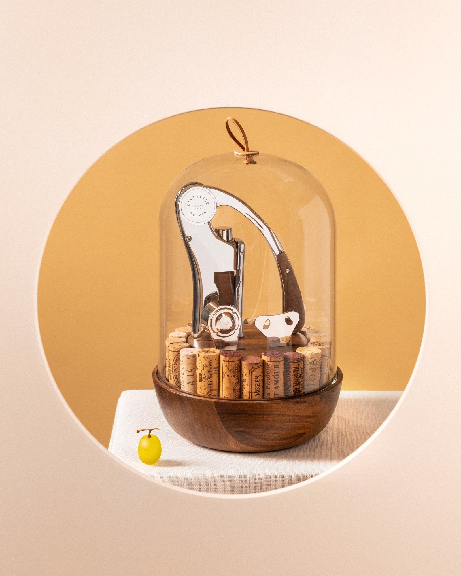 L'Atelier du Vin Oeno Motion Groom bajo campana de vidrio en composición artística con fondo dorado