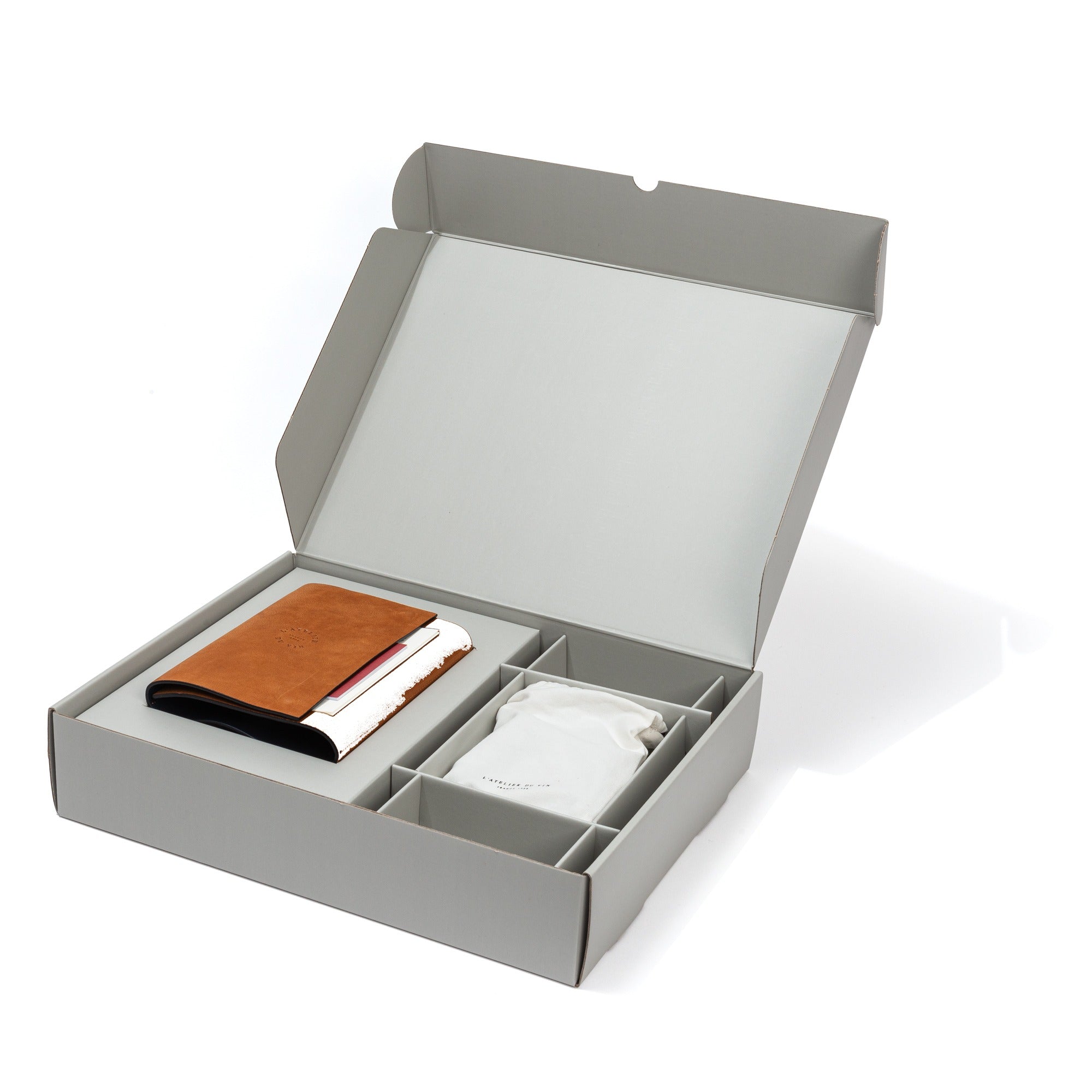 Caja abierta L'Atelier du Vin Oeno Motion Nomad con estuche de cuero y accesorios incluidos sobre fondo blanco