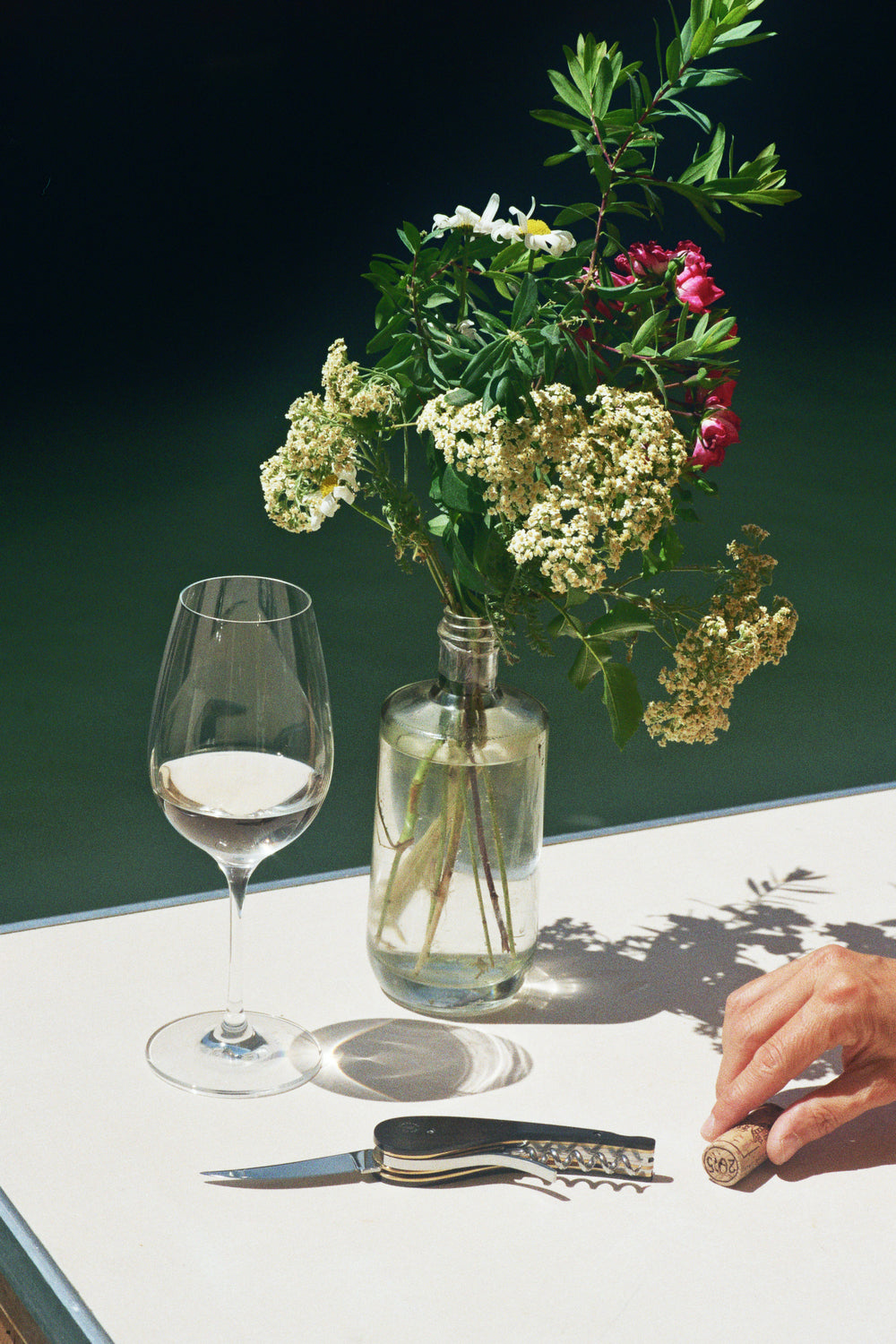 Sacacorchos sommelier L'Atelier du Vin Soft Machine Blade Le Pierre en mesa con copa de vino y flores silvestres