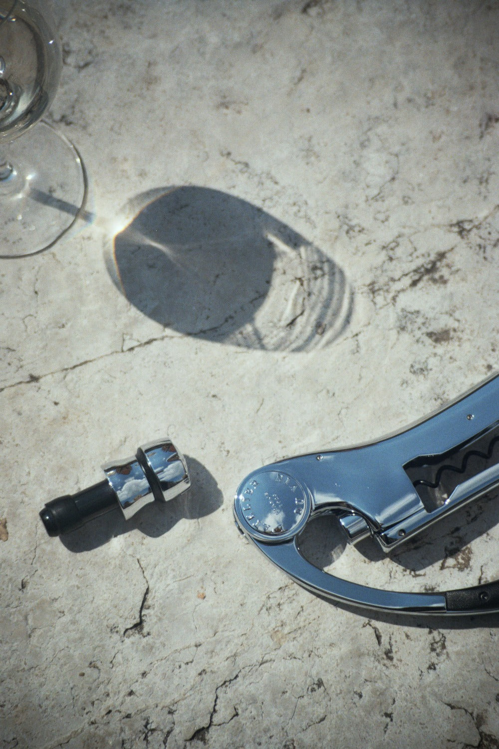 Sacacorchos Oeno Motion y tapón BubbleCork del set Up & Down L'Atelier du Vin sobre superficie de piedra al sol