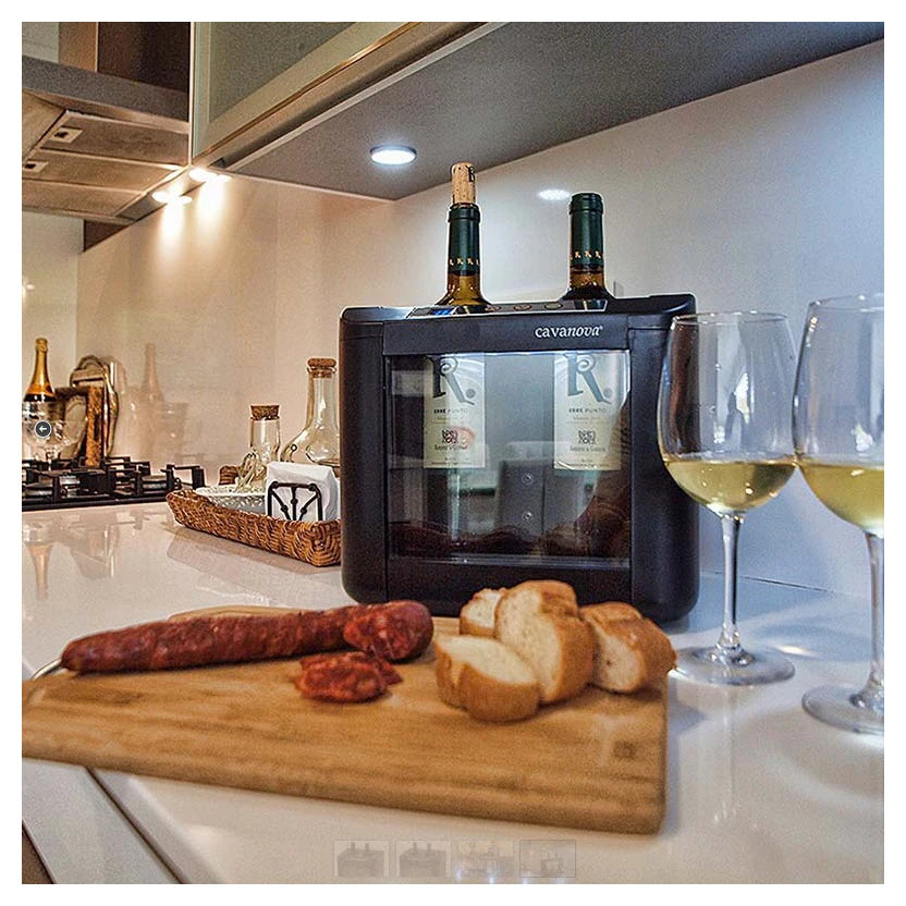 Enfriador de vino Cavanova en encimera de cocina junto a tabla con pan y embutidos y copas de vino blanco.