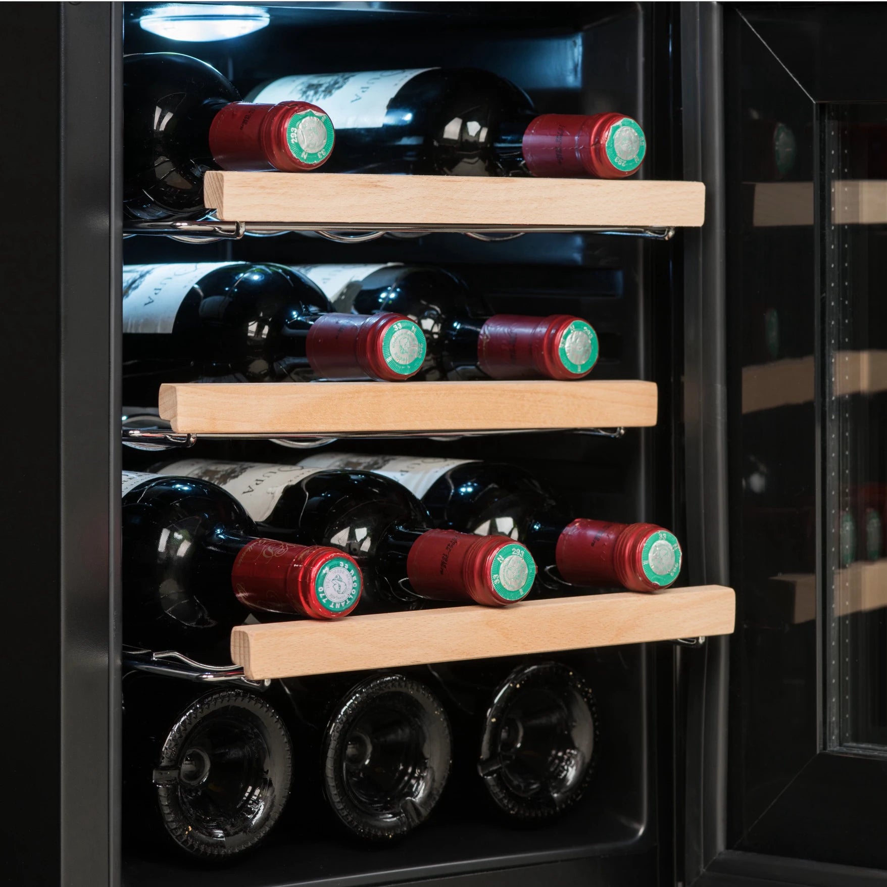 Detalle del interior de la vinoteca Climadiff CUVEE12 con estantes de madera y botellas de vino tinto colocadas horizontalmente bajo luz LED.