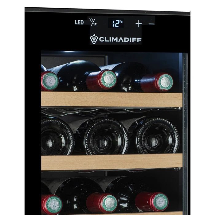 Vista cercana del panel digital de la vinoteca Climadiff CUVEE18 configurado a 12 °C, con tres filas de botellas de vino tinto almacenadas en estantes de madera.