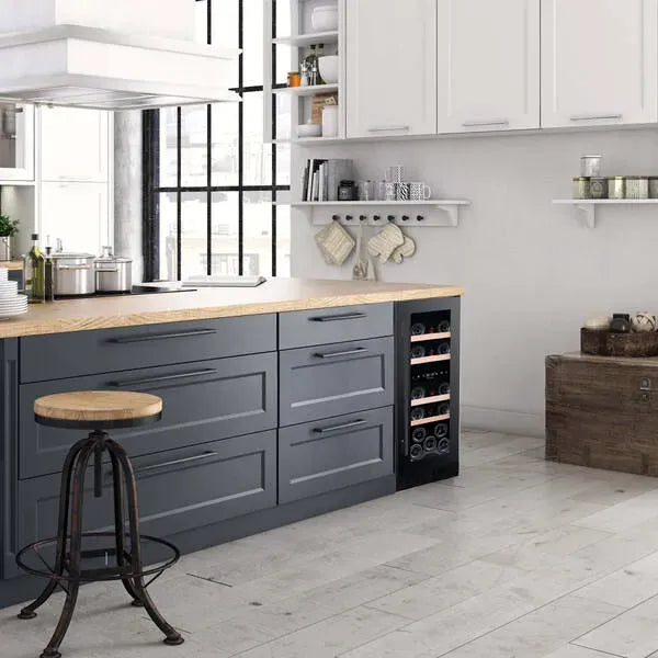 Cocina moderna con isla central de gabinetes grises y encimera de madera clara, que integra una vinoteca La Sommelière LSBU18DZ empotrada.