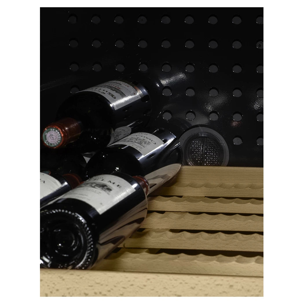 Detalle de botellas de vino depositadas en estantes de madera ergonómicos con fondo negro perforado de la CLASSIC194