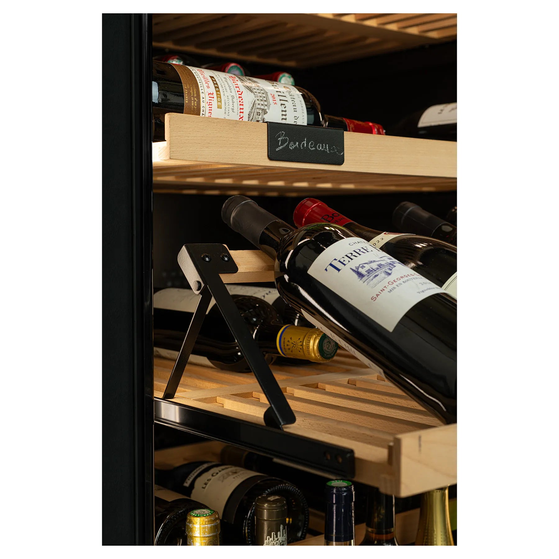 Detalle de estante de madera con soporte de presentación inclinada, mostrando una botella de vino en ángulo para facilitar la visualización de la etiqueta.