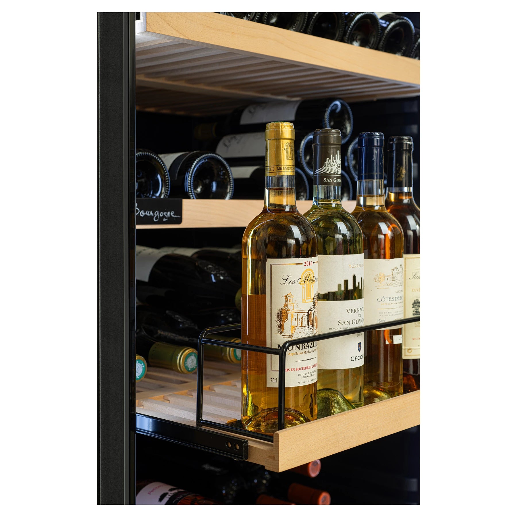 Primer plano de estante deslizante de madera con botellas de vino blanco en posición vertical, etiquetas visibles y botellas horizontales almacenadas al fondo.