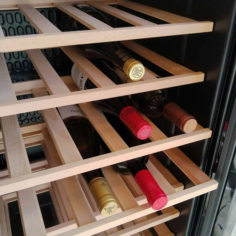 Detalle del interior de la vinoteca Cave Vinum CV-28CWS con varias botellas de vino colocadas horizontalmente sobre estantes de madera clara.