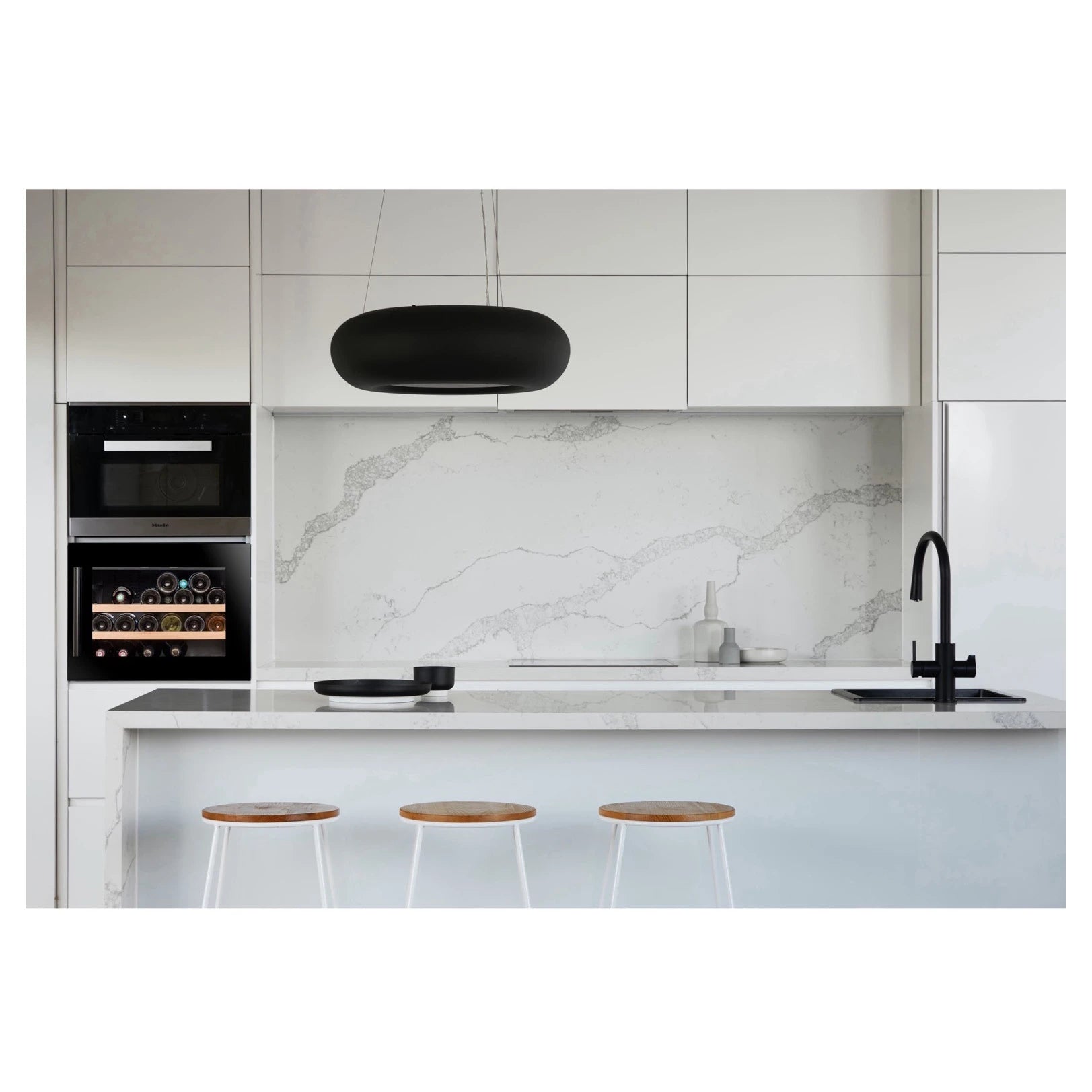 Cocina moderna blanca con vinoteca integrable Climadiff CBI28S1B para 28 botellas instalada en columna junto a horno.