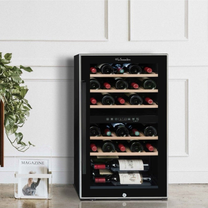 Vinoteca 29 botellas La Sommelière ECS31.2Z doble zona instalada en una salón moderno, cargada de botellas de vino tinto y blanco.
