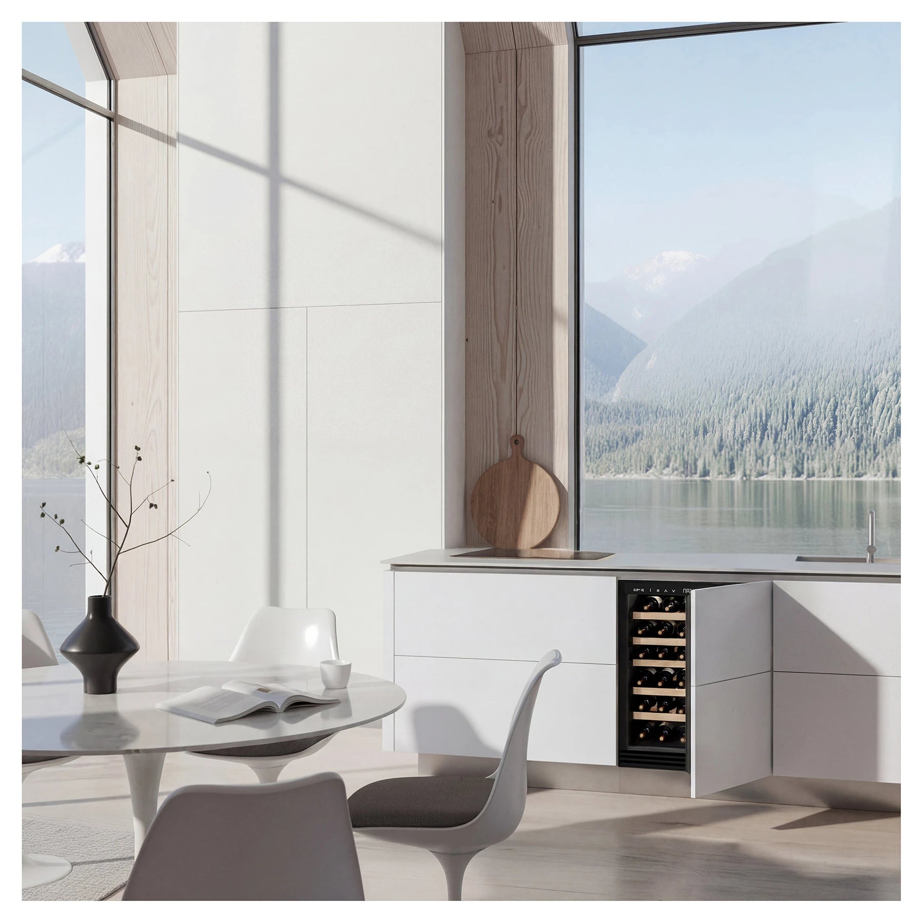 Cocina luminosa de estilo escandinavo frente a un ventanal con vista a un lago y montañas; una vinoteca empotrada con puerta abierta revela botellas de vino almacenadas en estantes de madera.