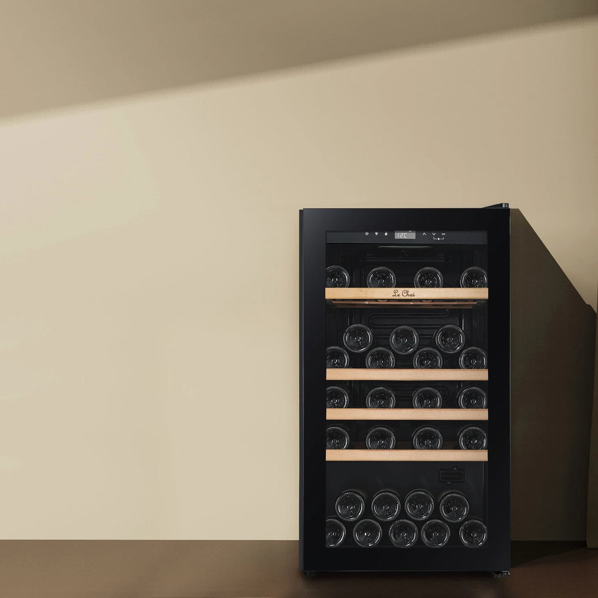 Vinoteca Le Chai LCT1FS49 de 49 botellas, colocada junto a una pared, con los estantes de madera sin frontal.