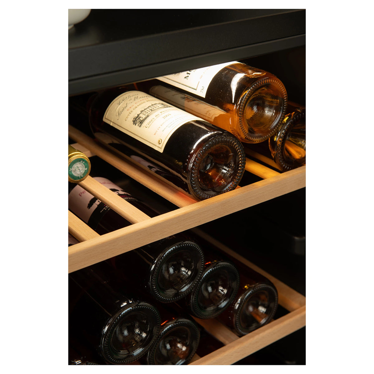 Detalle de botellas de vino sobre las bandejas de madera de la vinoteca La Sommelière SMART95DZ