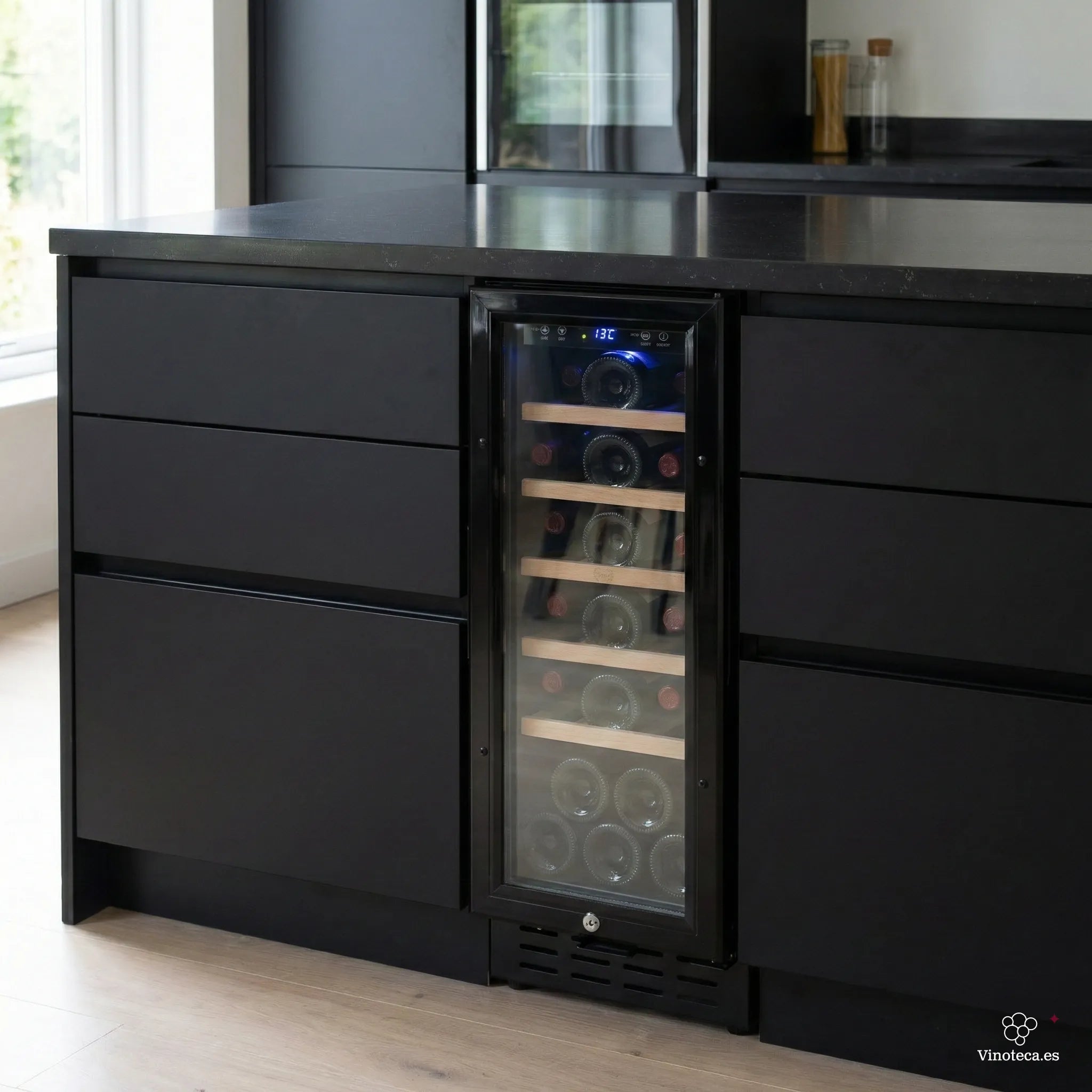 Vinoteca encastrable negra instalada bajo encimera en cocina moderna, con puerta de vidrio, estantes de madera y botellas de vino visibles con iluminación interior azul.