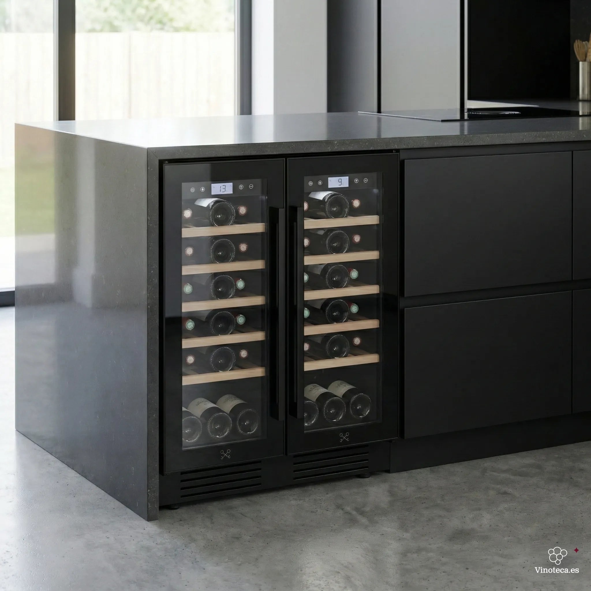 Vinoteca doble zona Les Petits Champs CAVCEDB42 instalada bajo encimera en cocina moderna, con puertas de cristal, estantes de madera y botellas visibles en ambos compartimentos.