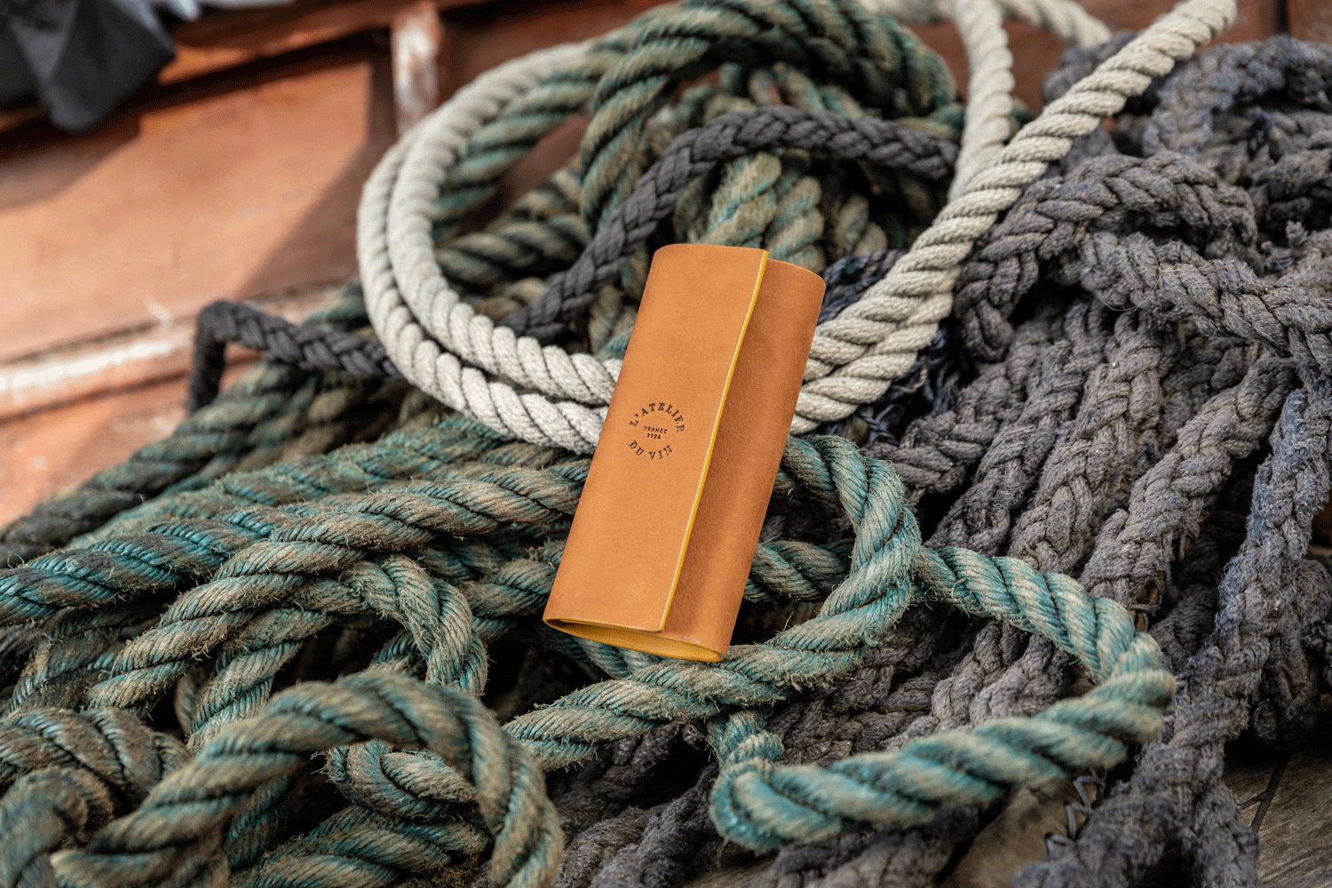 Estuche Soft Machine Nomad L'Atelier du Vin en cuero sobre cuerdas marinas en entorno náutico