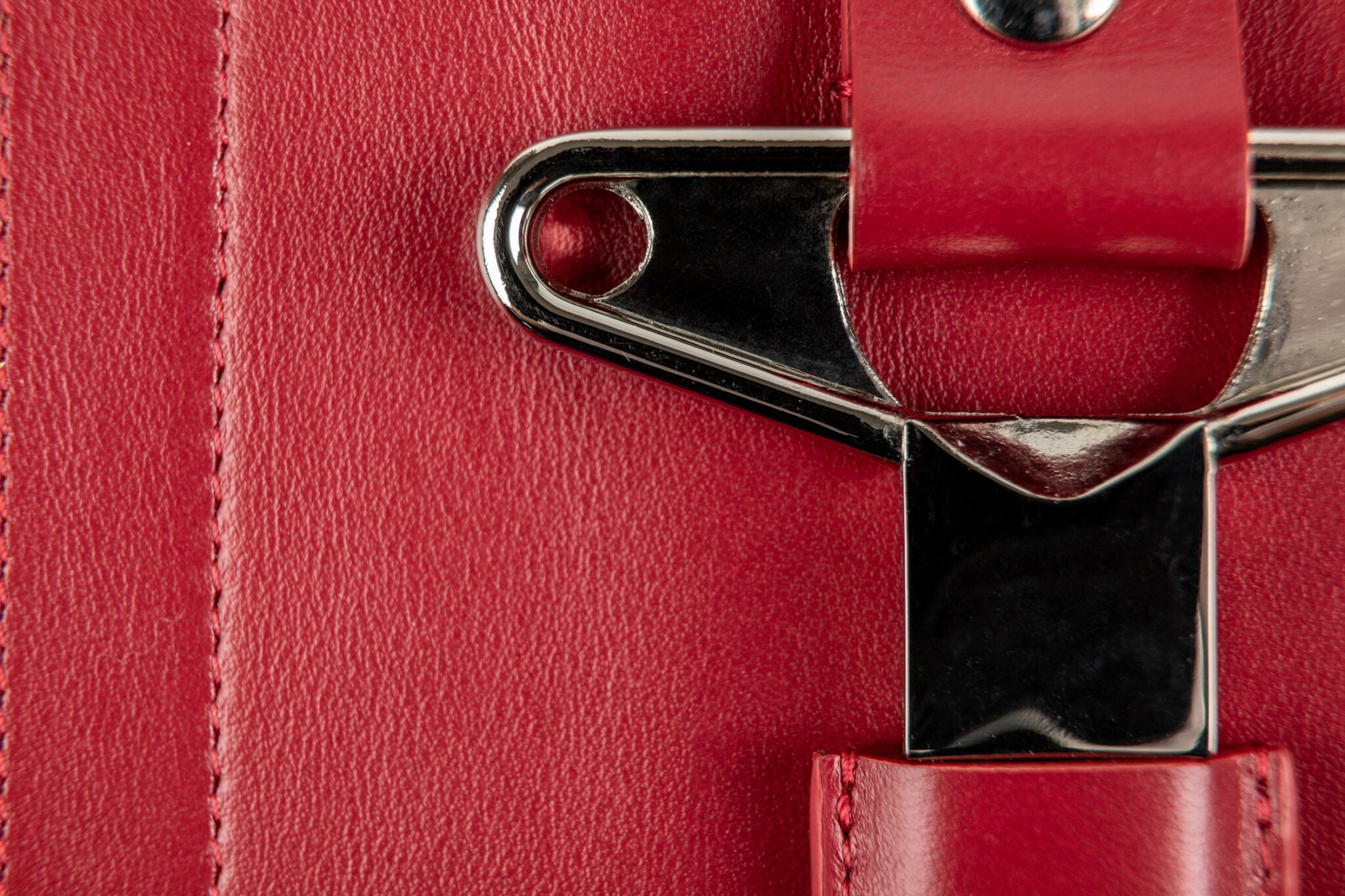 Detalle del cortacápsulas metálico alojado en el cuero rojo del estuche L'Atelier du Vin Oeno Collection Nomad