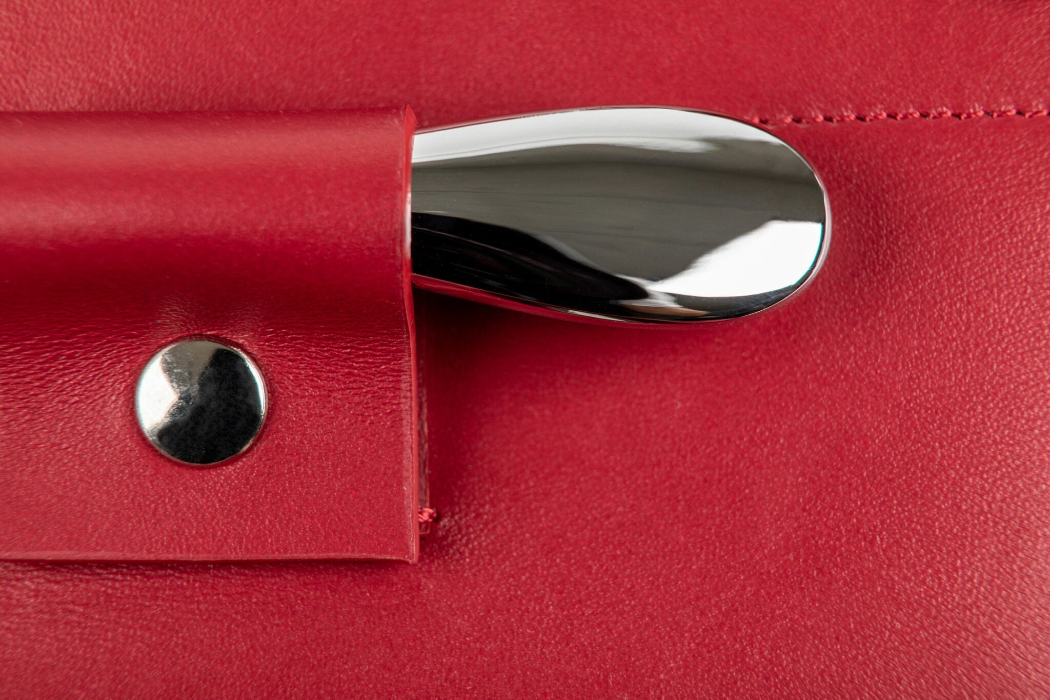Detalle del tapón metálico pulido alojado en bolsillo de cuero rojo del estuche L'Atelier du Vin Oeno Collection Nomad