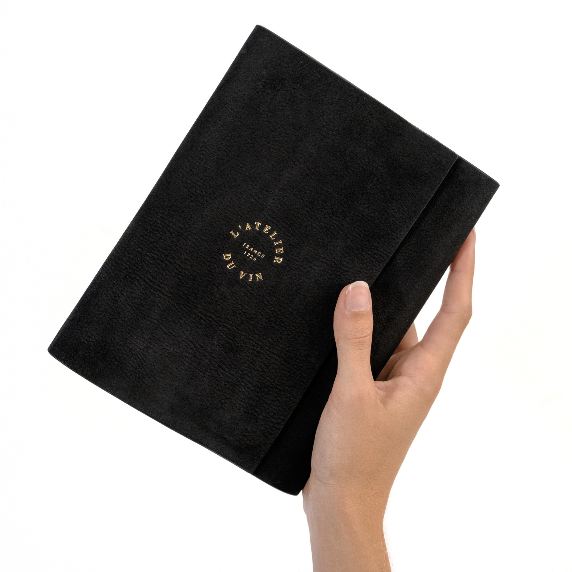 Mano sosteniendo el estuche cerrado Oeno Motion Gold Nomad L'Atelier du Vin con logo dorado bordado
