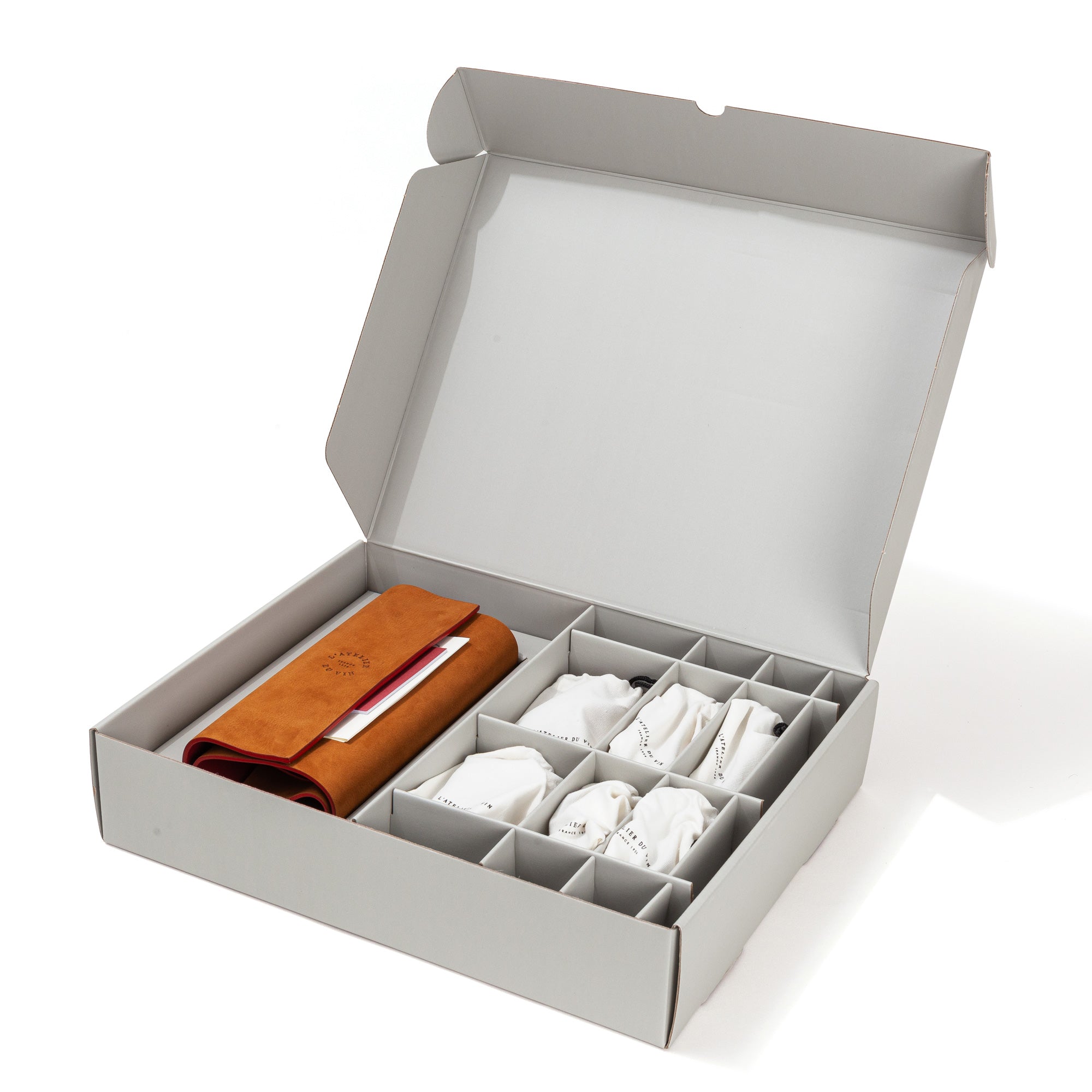 Caja de envío abierta del estuche L'Atelier du Vin Oeno Collection Nomad con accesorios en compartimentos