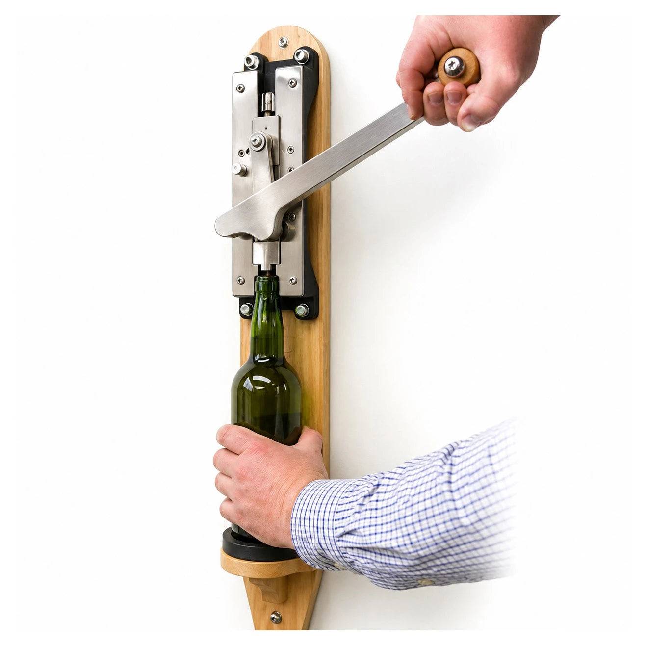 Descorchador de pared Coem en acero inoxidable, detalle de uso con la mano accionando el sistema de carraca.