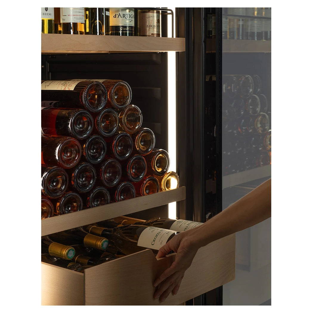 Mano extrayendo bandeja extraíble de La Sommelière VIP177 Edition con botellas apiladas en el interior iluminado