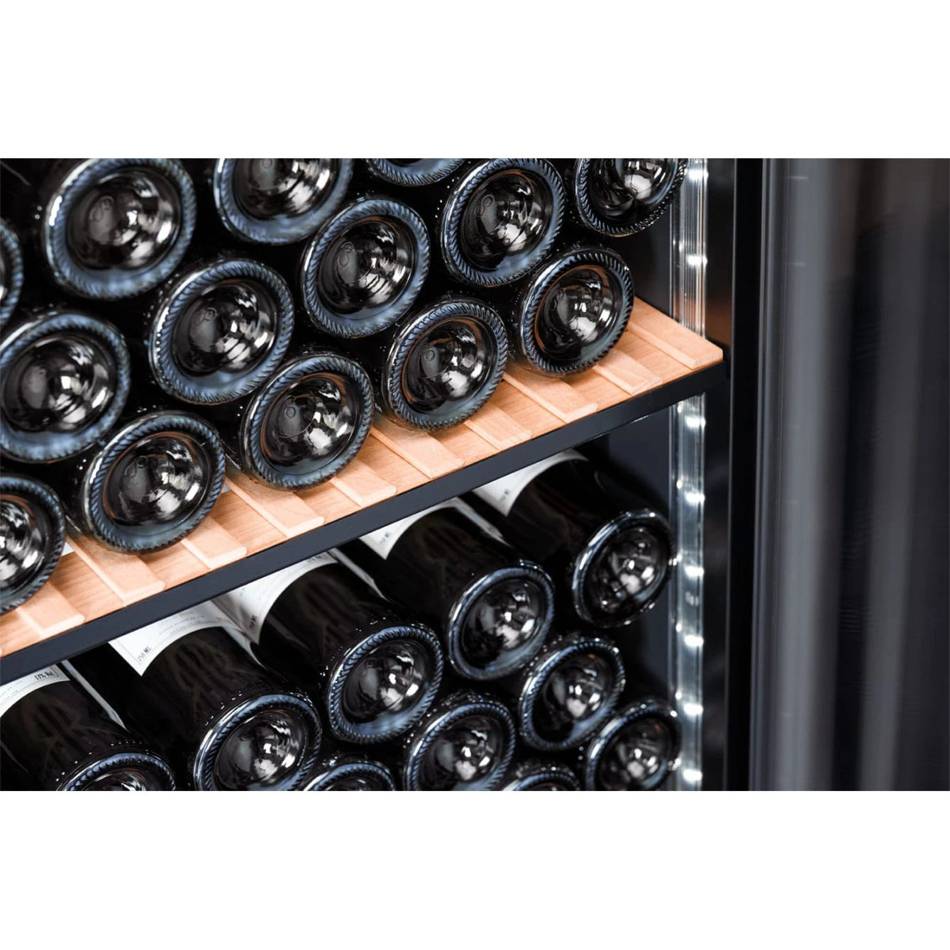 Detalle del interior de la Vinoteca 200 botellas mQuvée VELVET 125 Premium Package, mostrando botellas de vino almacenadas horizontalmente sobre estantes de madera, con iluminación LED blanca integrada en los laterales.