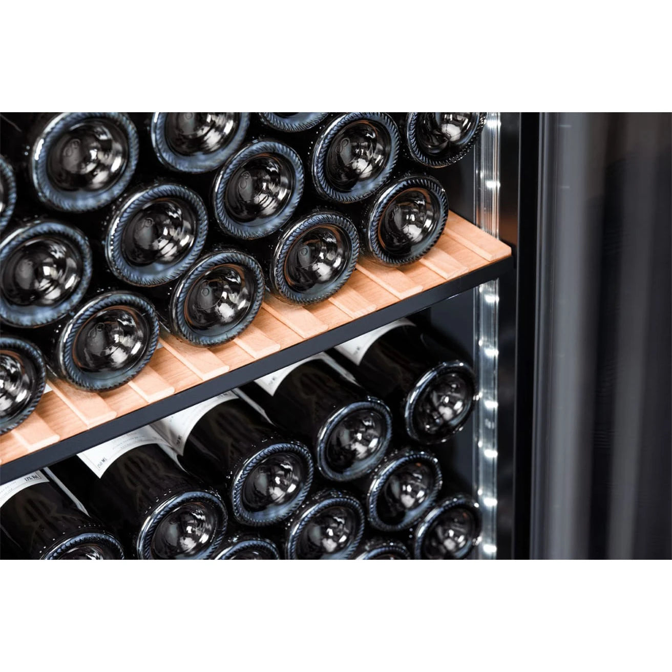 Detalle del interior de la Vinoteca 200 botellas mQuvée VELVET 125 Premium Package, mostrando botellas de vino almacenadas horizontalmente sobre estantes de madera, con iluminación LED blanca integrada en los laterales.