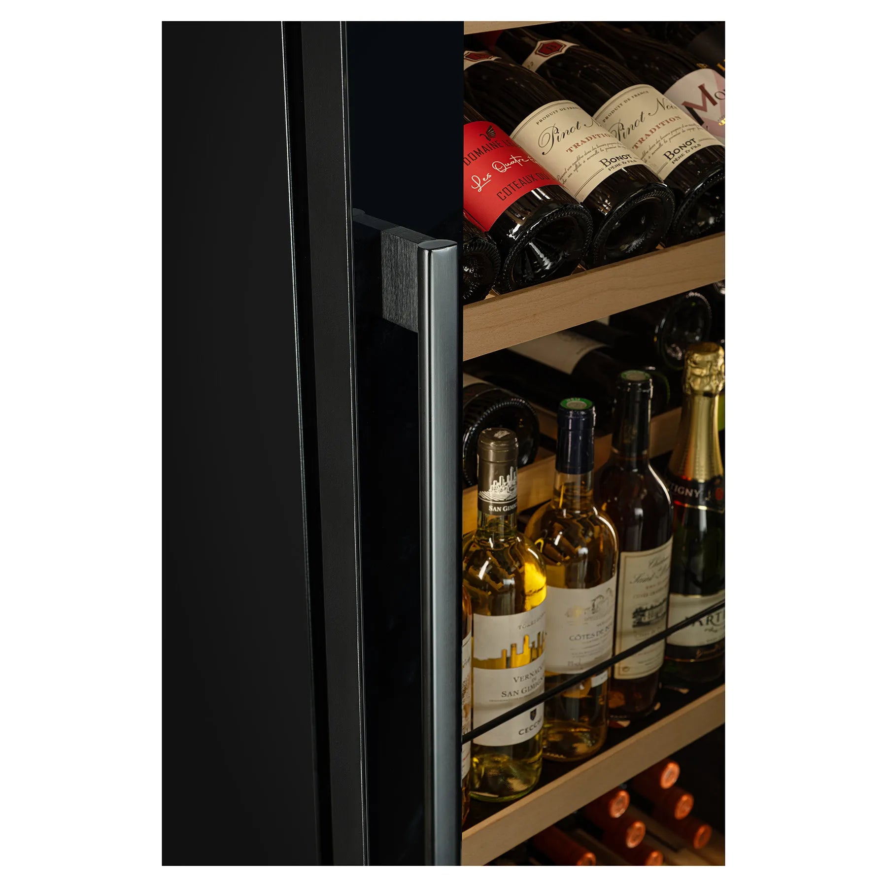 Detalle del tirador de puerta de vinoteca junto a estantes de madera con botellas de vino almacenadas.