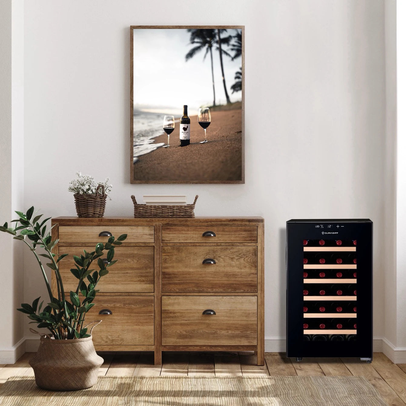 Vinoteca negra Climadiff CUVEE28 con puerta frontal de vidrio y estantes horizontales, diseñada para almacenar hasta 28 botellas de vino, ubicada junto a una cómoda de madera en un espacio interior moderno y cálido.